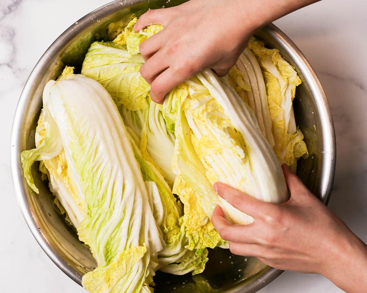 Flipping the salted napa cabbage in bowl.