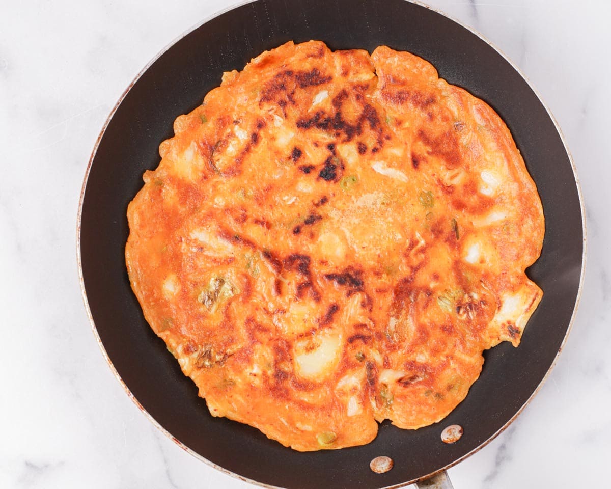 Kimchijeon flipped in pan.