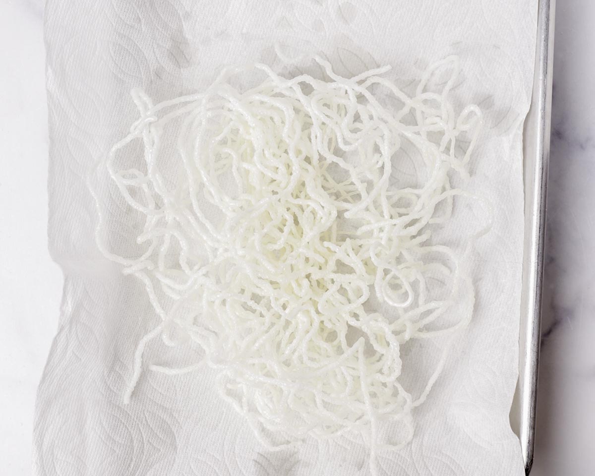 Fried rice vermicelli draining on paper towel.