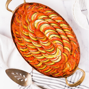 Top down of a baked ratatouille in an oval pan.