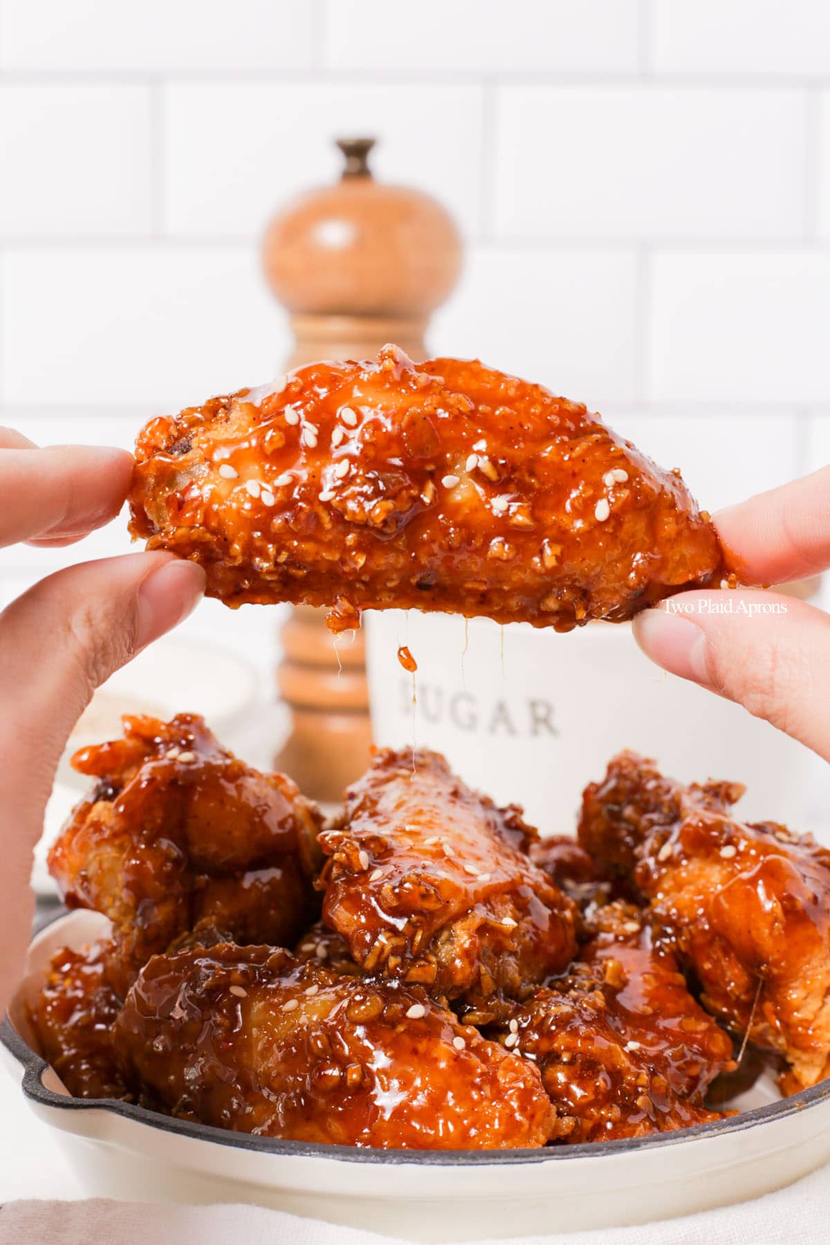 Holding Korean fried chicken with soy garlic sauce.