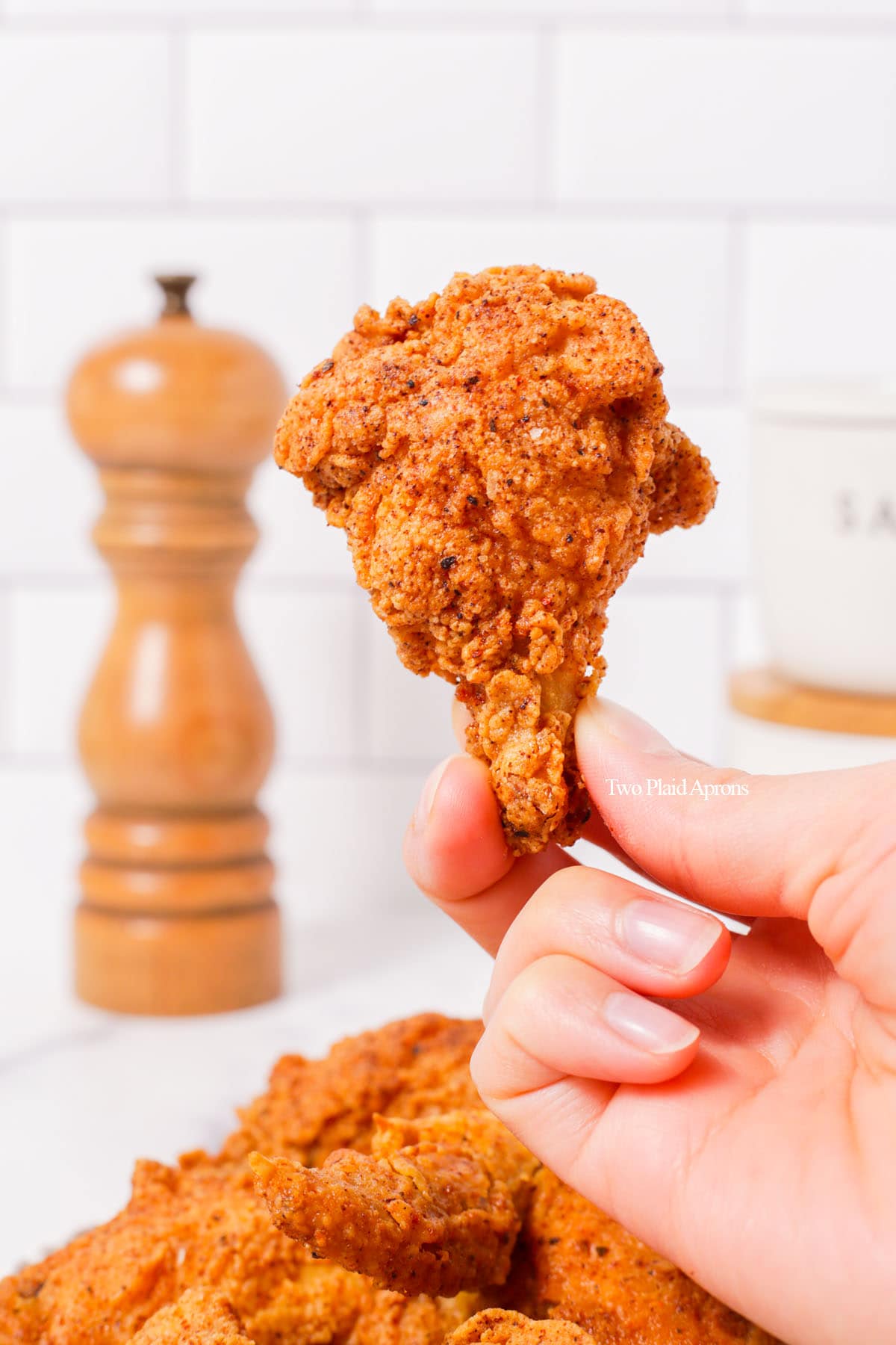 Holding a Korean fried chicken wing.