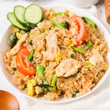 Thai fried rice with sliced cucumbers on the plate.