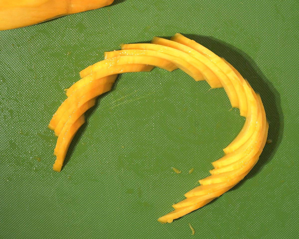 Curving the mango slices.