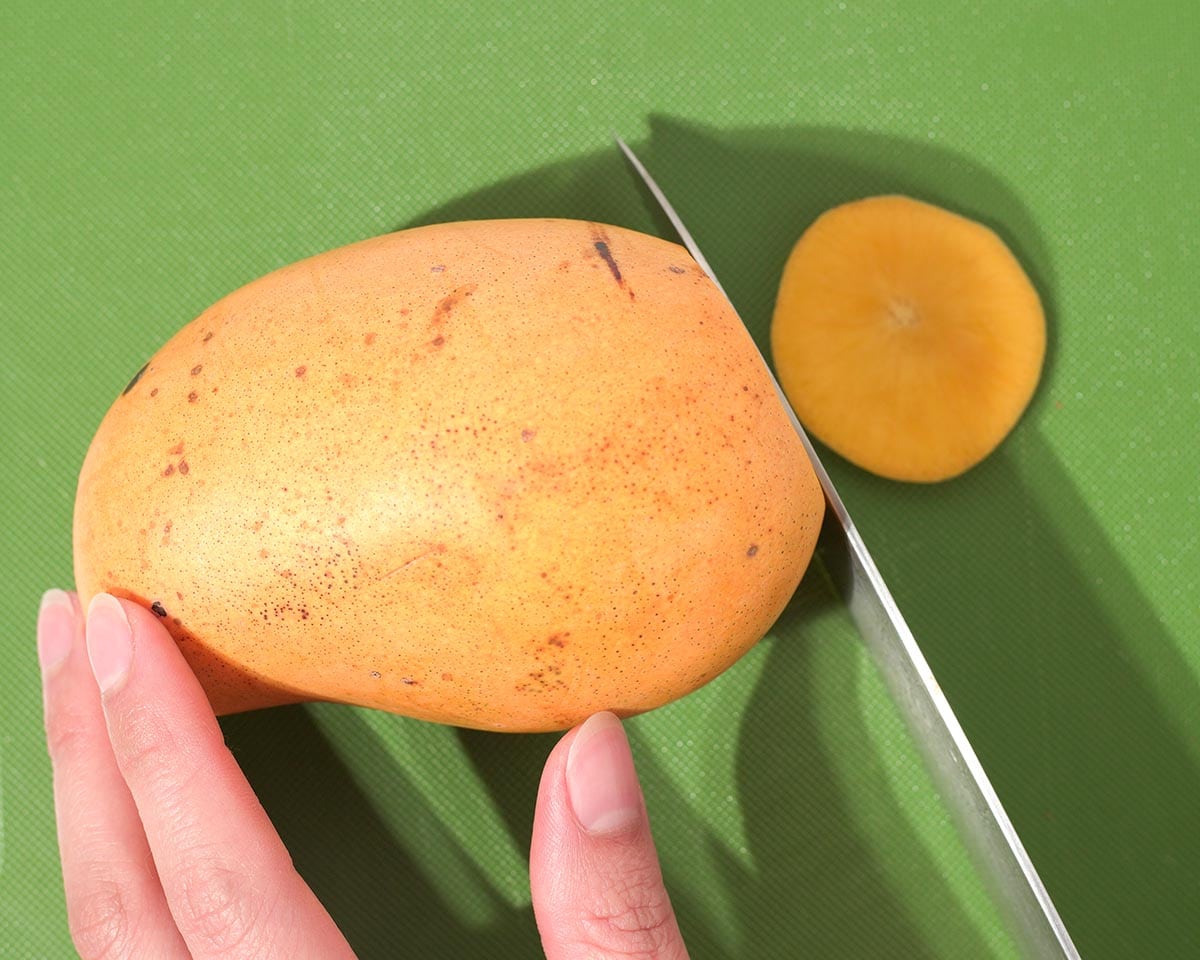 Cutting the end off the mango.