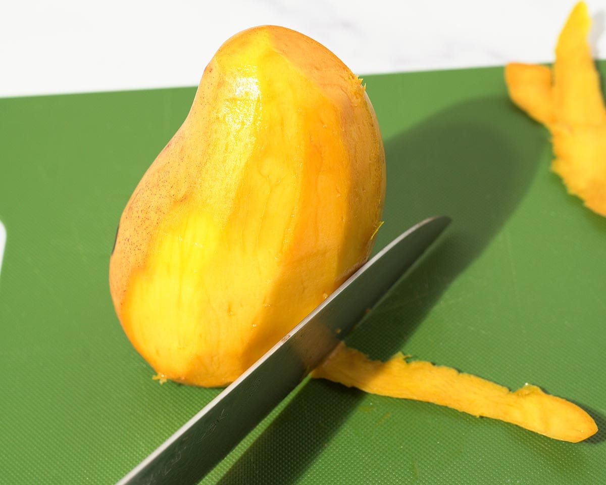 Cutting the skin off the mango.