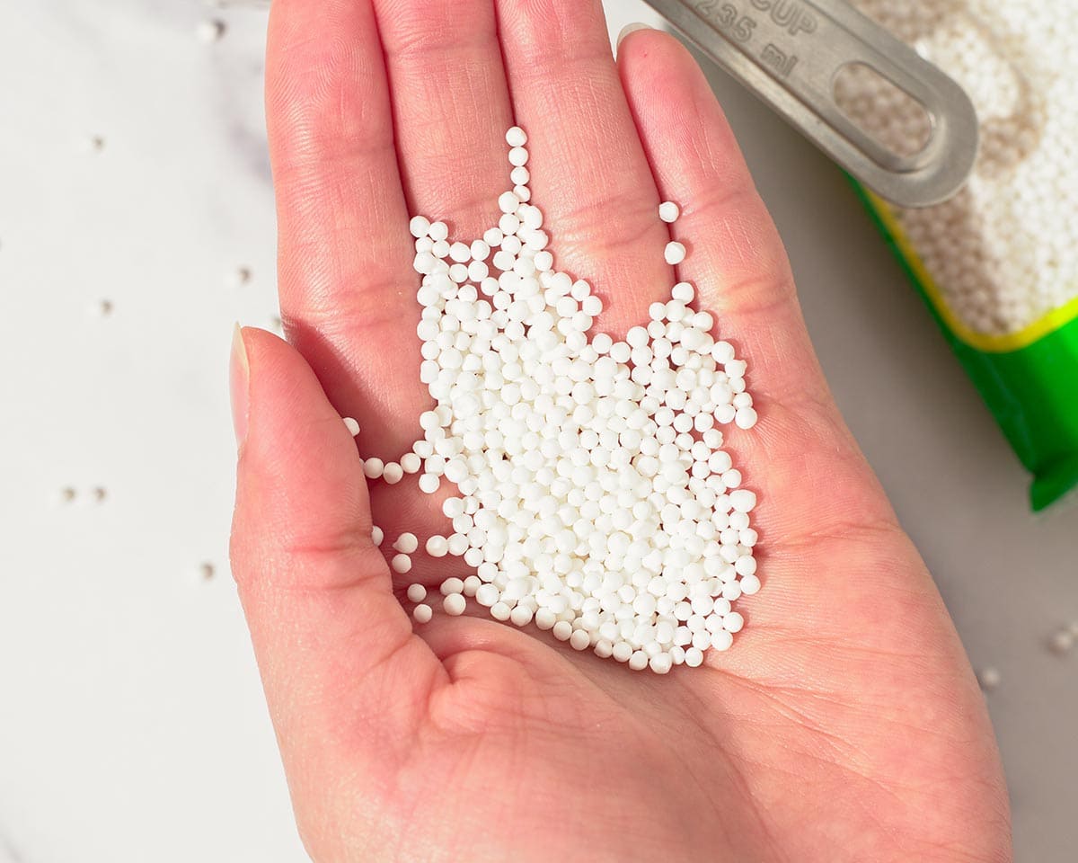 Holding uncooked sago pearls.