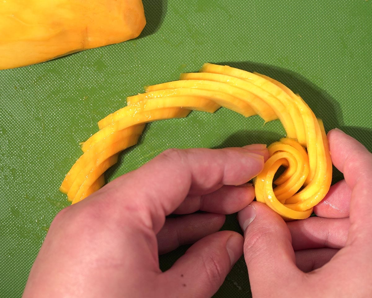 Rolling the mango slices.