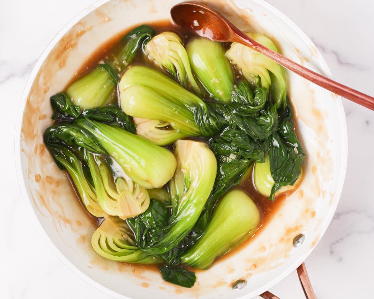 Tossing the bok choy in the sauce.