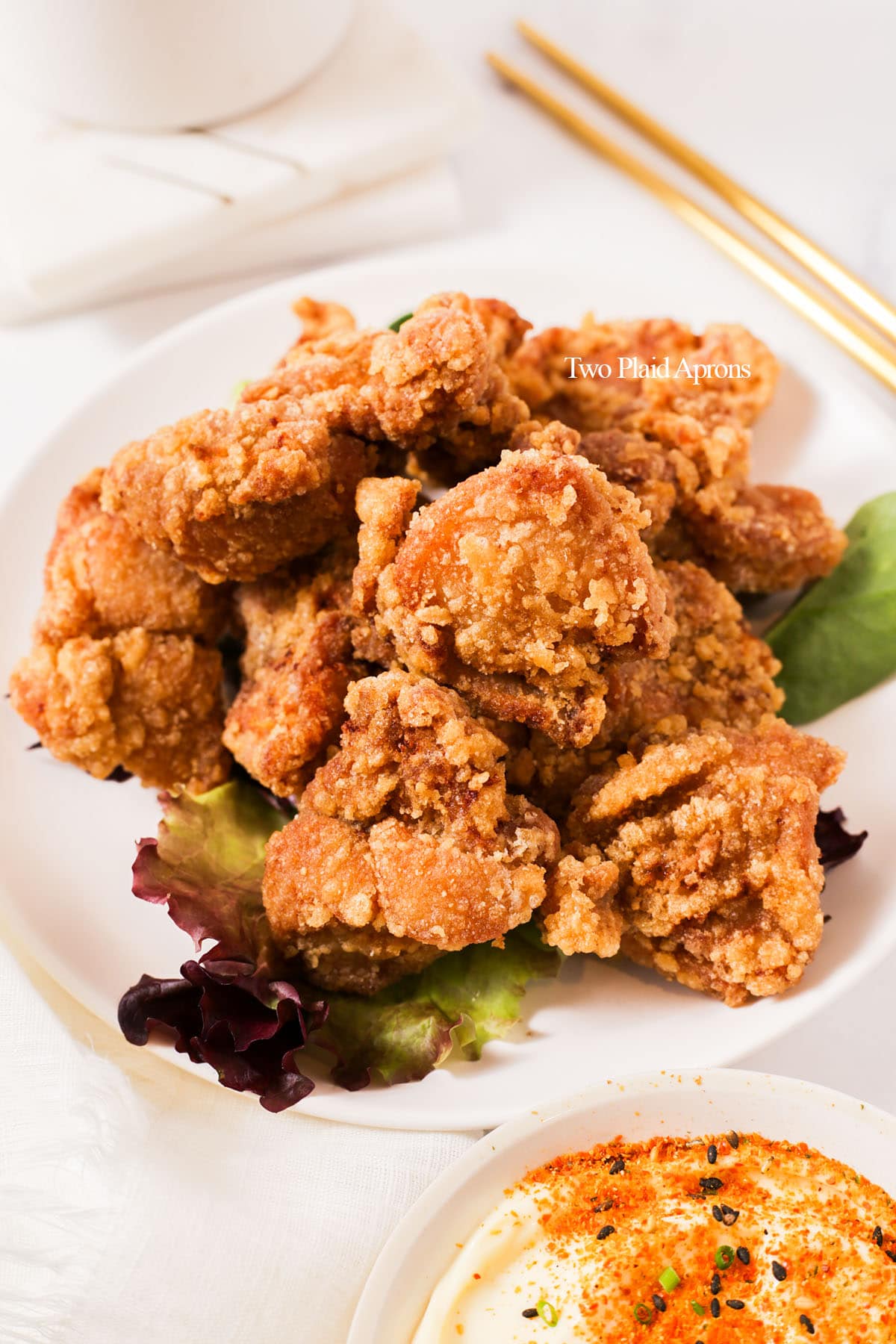 Karaage chicken on plate with dipping sauce.