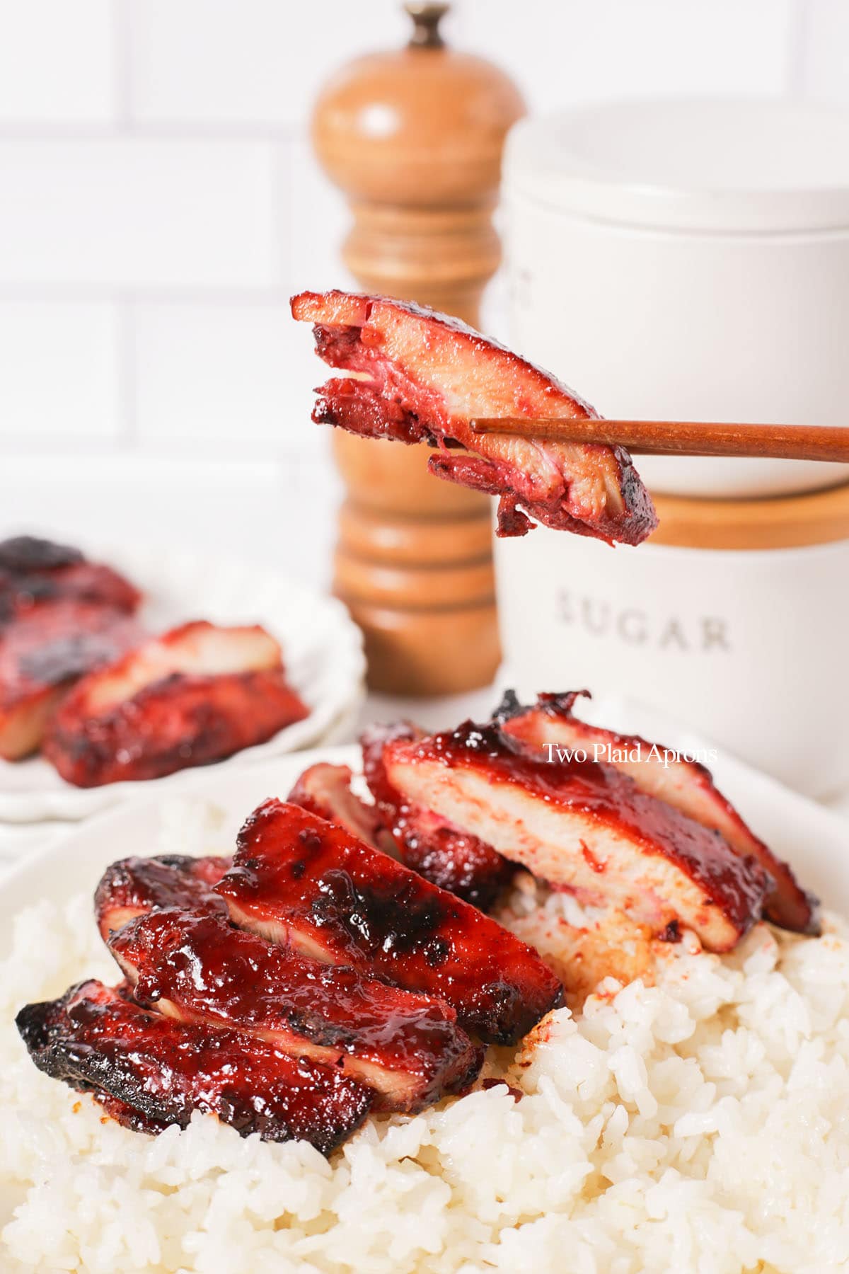 Holding a piece of char siu chicken.