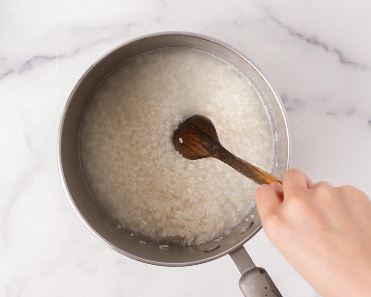 Stirring the rice in the pot after it boils