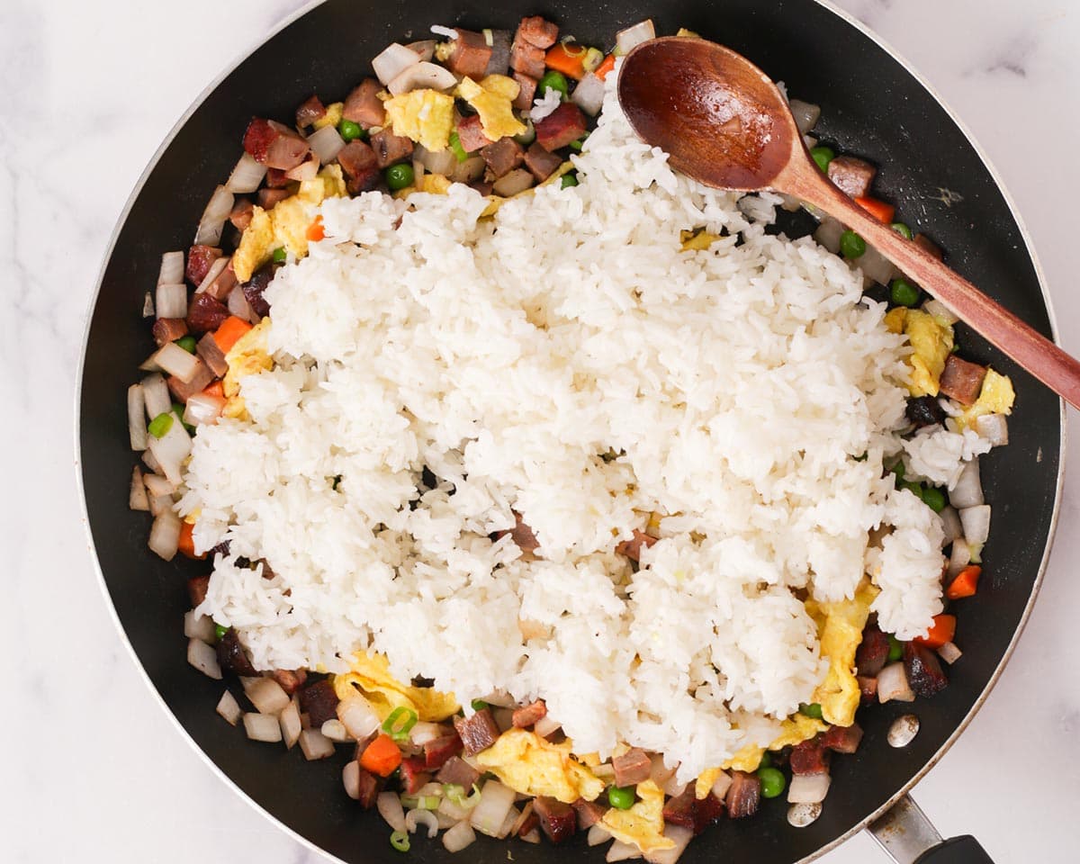 Adding the day old rice to the pan.