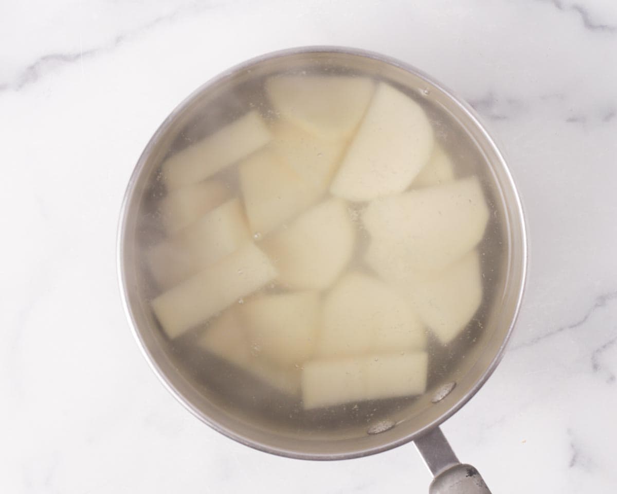 Boiling potato in water.