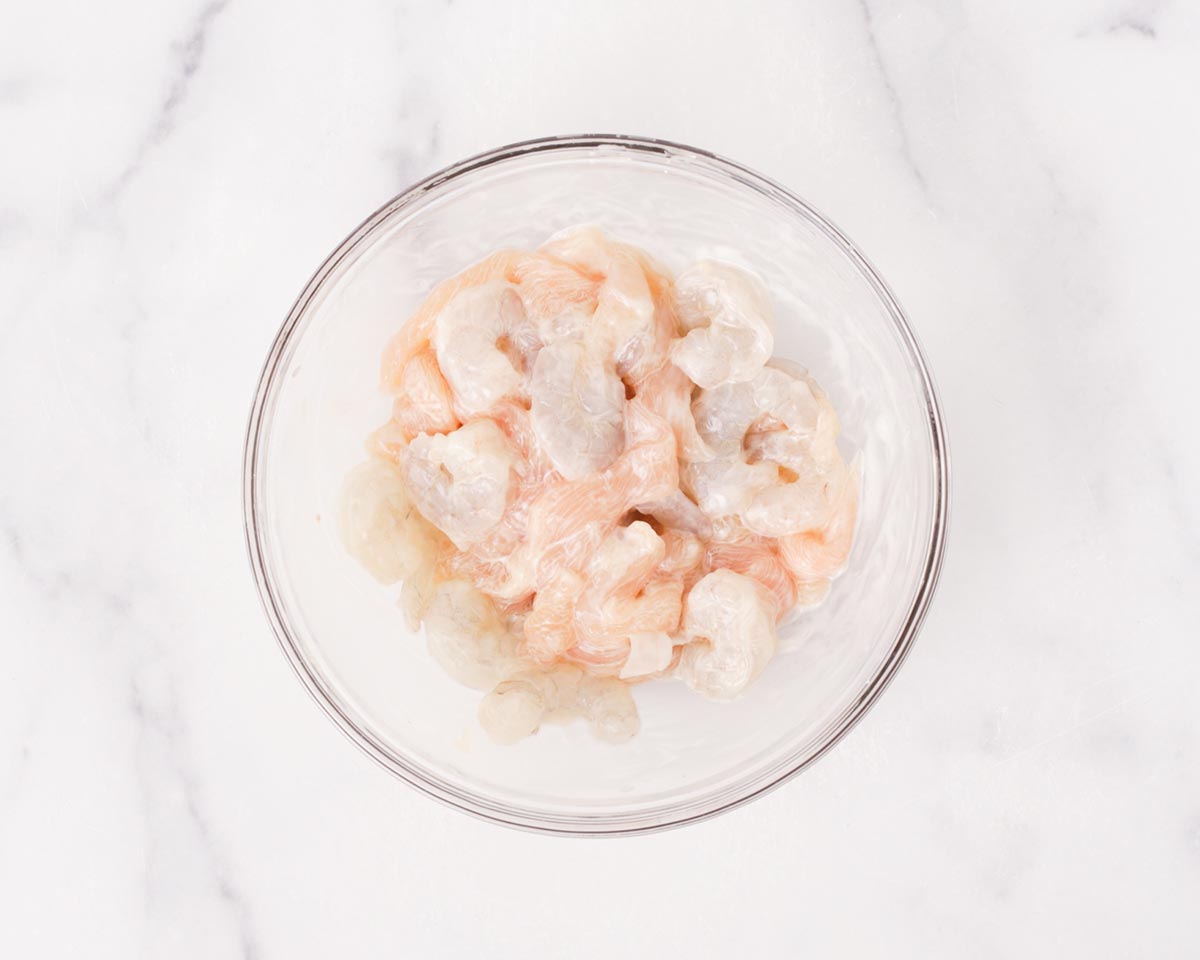 Mixing in cornstarch and then oil to the shrimps and sliced chicken.