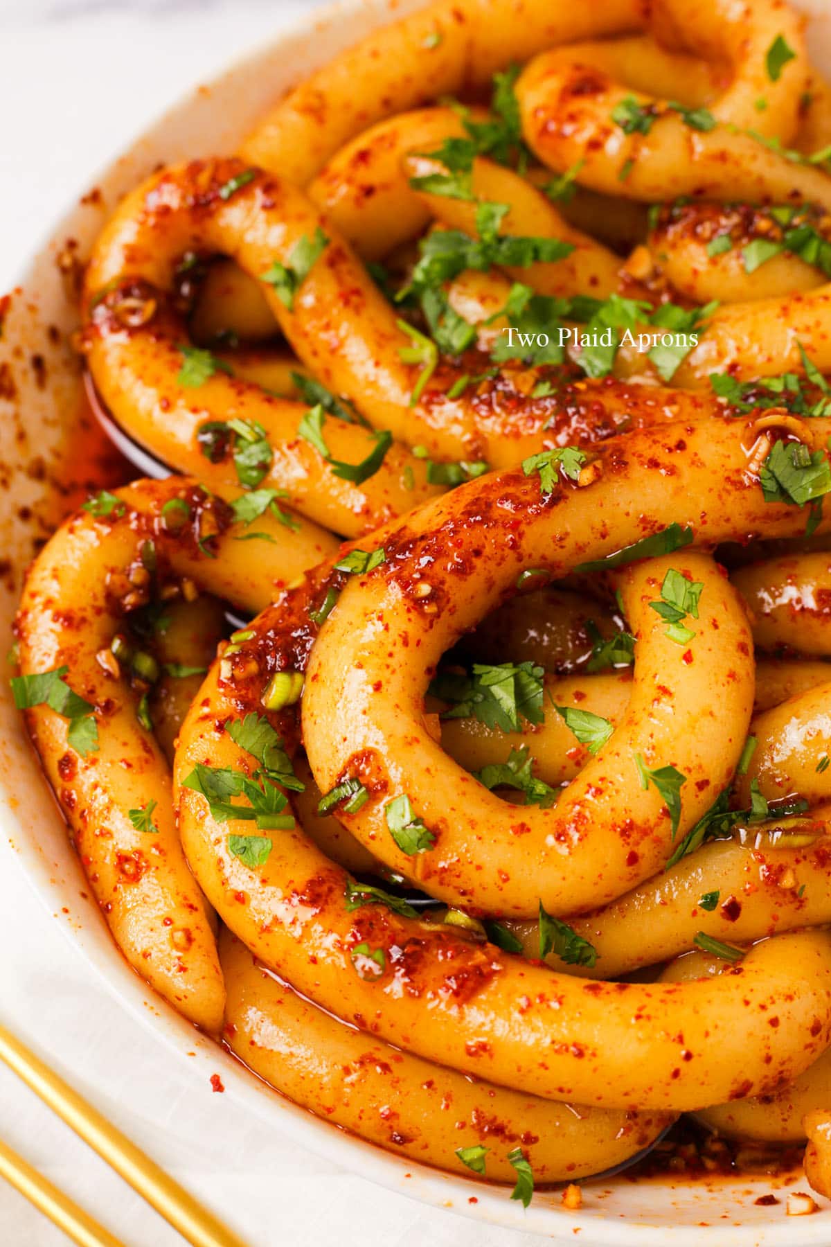 Close up of spicy potato noodles topped with cilantro.