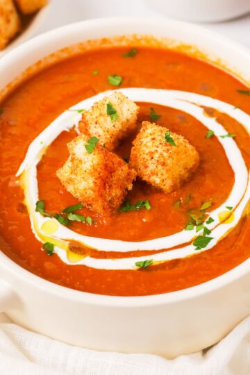 A bowl of roasted tomato soup with croutons.