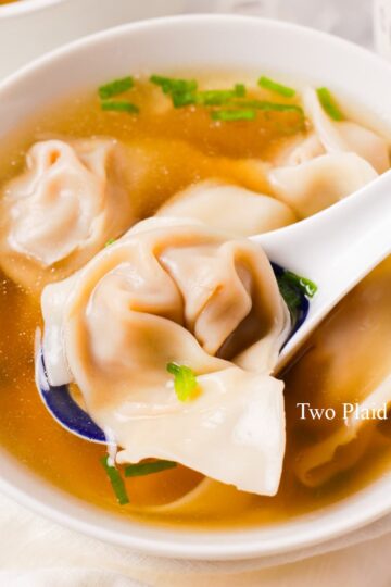 Holding a spoonful of wonton soup.
