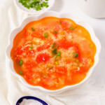 Tomato egg drop soup with green onions.