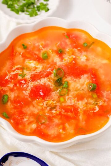 Tomato egg drop soup with green onions.