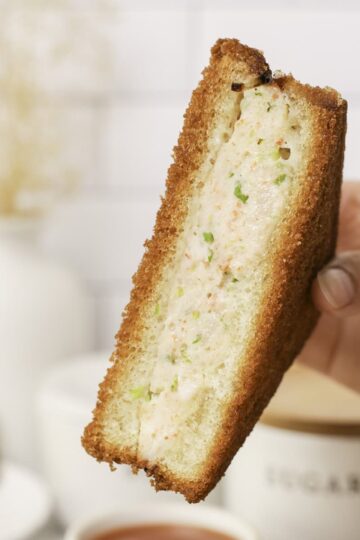 Holding a shrimp toast.