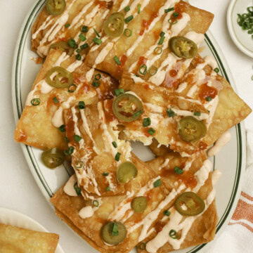 Crab rangoon nachos on a plate with one torn open.