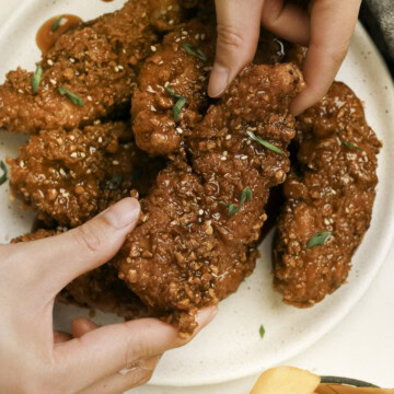 Holding a honey garlic chicken tender.