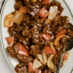 Beijing Beef on a plate with a spoon.