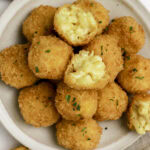 Crispy mac and cheese bites with a couple showing the cheesy insides.