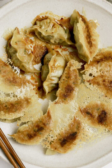 A plate of pork gyoza with crispy skirt.