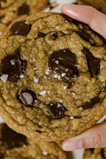 Holding a brown butter chocolate chip cookie in hand.
