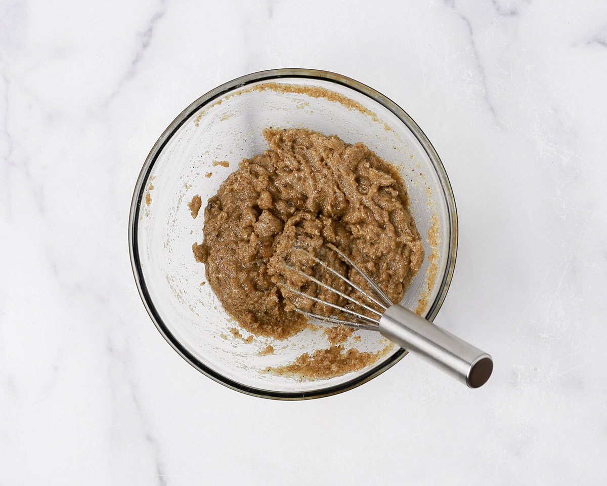 Browned butter, white granulated sugar, and brown sugar whisked together in a bowl.